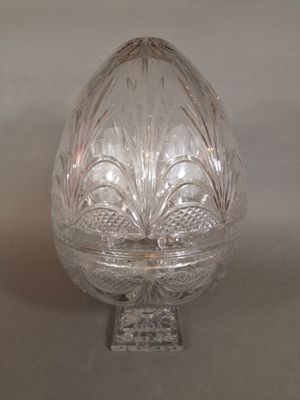 a glass egg shaped object on a stand on a table