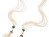 un collier de perles blanches et de diamants orné de pompons, sur fond blanc