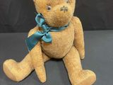 a brown teddy bear with a blue bow on it ' s neck