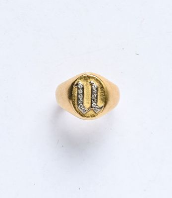 une chevalière en or et diamants sur laquelle figure la lettre « u »