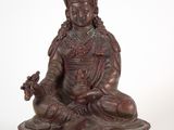 une statue antique en bronze représentant une femme assise en position du lotus