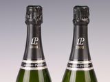 two bottles of champagne sitting next to each other on top of a table