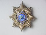 une image représentant une broche bleue et dorée ornée d'une étoile
