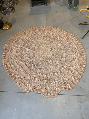 a round rug made out of shells on the floor