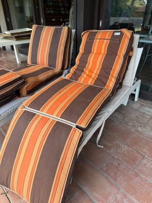 deux chaises longues qui se trouvent dehors, sur la terrasse