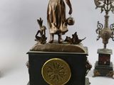 a bronze statue of a woman holding a flute and a candelabra