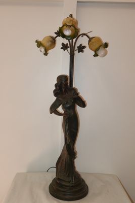a statue of a woman holding a bouquet of flowers on a table