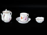 trois tasses et soucoupes posées sur une surface noire