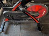 a red and black exercise bike on display in a gym