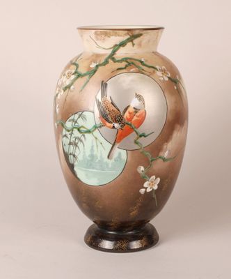 un vase sur lequel sont peints un oiseau et des fleurs