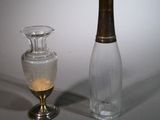 un petit vase en verre à côté d'une petite bouteille en verre