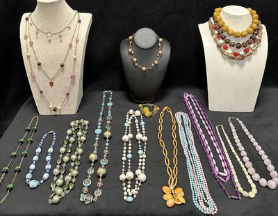 many necklaces and bracelets on display on a table