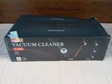 a box of vacuum cleaner sitting on a bed