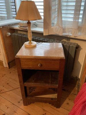 a small table with a lamp on it in front of a window
