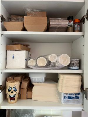une armoire contenant de nombreux objets, sur laquelle est posé un masque
