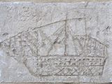 une image représentant une plaque en pierre sur laquelle est sculpté un navire