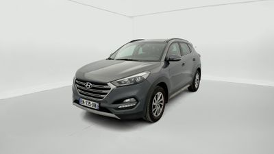 the front view of a grey 2017 hyundai tucson parked in a white room