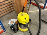 un aspirateur jaune et noir posé par terre dans un entrepôt