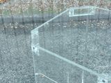 a glass table with a glass top on a gravel ground