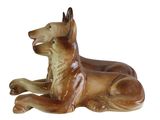 a figurine of a dog laying down on the ground