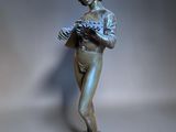 bronze statue of a woman holding a bird on a pedestal