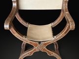 an image of a wooden chair with a leather seat on a black background