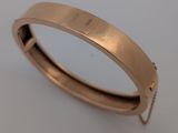 gros plan d'une bague en or sur une surface blanche