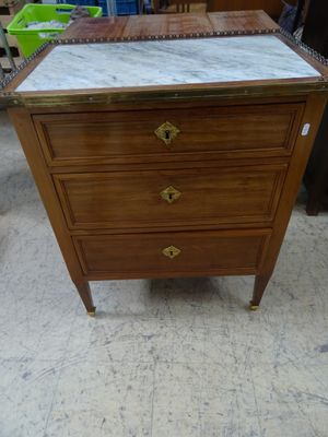 une photo d'une commode au plateau en marbre dans un magasin