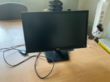 a computer monitor sitting on top of a wooden desk
