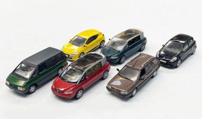 plusieurs petites voitures sont alignées sur une surface blanche