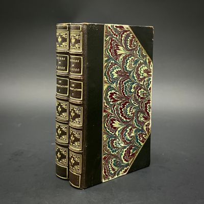 un vieux livre posé sur une table noire, près d'un mur gris
