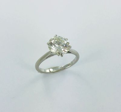 a close up of a diamond ring on a white surface