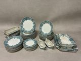 an assortment of blue and white plates and spoons on a table