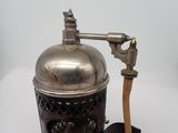 a small metal object with a wooden handle on a white surface