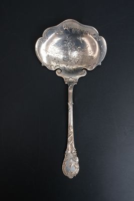 une vieille cuillère en argent accrochée à un mur noir sur fond noir