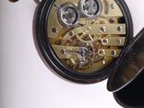 a close up of a pocket watch on a white surface