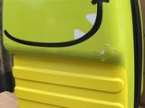 un gros plan d'une valise jaune ornée d'un smiley