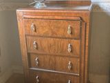 a small chest of drawers with a lamp on top of it