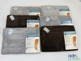 Quatre paires de coussinets pour les pieds sont présentées sur un lit, accompagnées d'étiquettes.