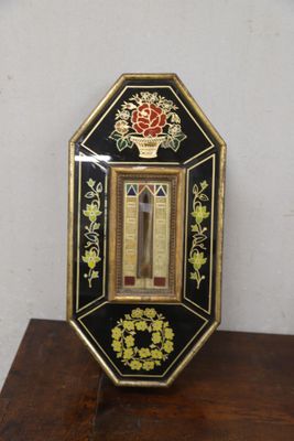 a small black and gold clock on a wooden table