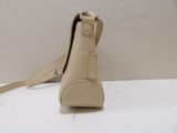 beige leather purse with strap on a white surface