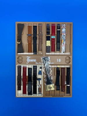 une boîte en bois remplie de ceintures de différents types