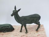 a statue of a deer and a cow on a marble base