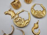 a group of gold jewelry including earrings, rings, and rings