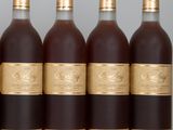 four bottles of wine are lined up on a table