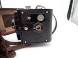 an old camera sitting on a table next to a suitcase