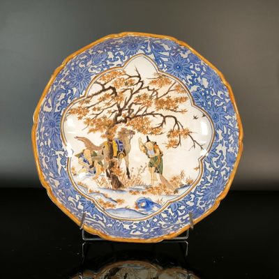 a blue and white plate with a painting on it