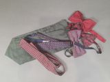 three ties and a bow tie on a white table
