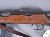 an old rifle with a wooden frame and a leather strap