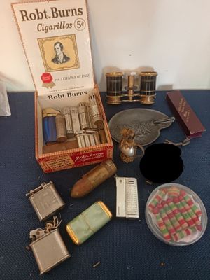 un paquet de cigarettes, un briquet, un étui à briquet et d'autres objets posés sur une table
